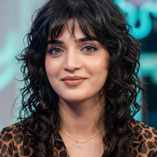 "Japanese wolf haircut for curly hair with feathered shag layers, wispy bangs, defined curls, and lightweight textured volume."