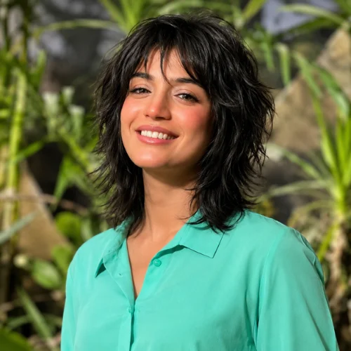 Shaggy short wolf cut haircut with choppy textured layers, wispy bangs, and natural volume, showcasing a modern women's wolf hairstyle .