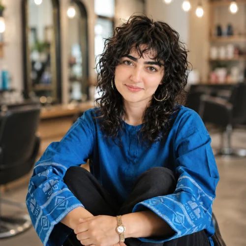 Short curly wolf cut haircut with defined textured curls, layered volume, and curly bangs for a bold, modern hairstyle .